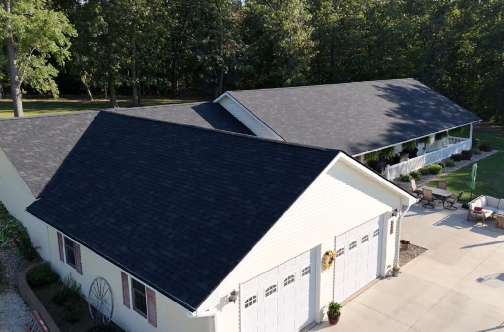 A Surge Exteriors team member inspecting a completed residential roofing project in Quincy, IL, showcasing expertise and reliability. Residential Roofer near me.